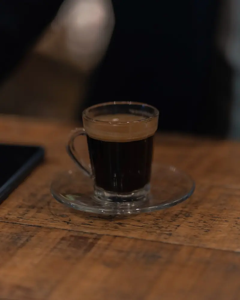 Espresso v sklenenej šálke na drevenom stole